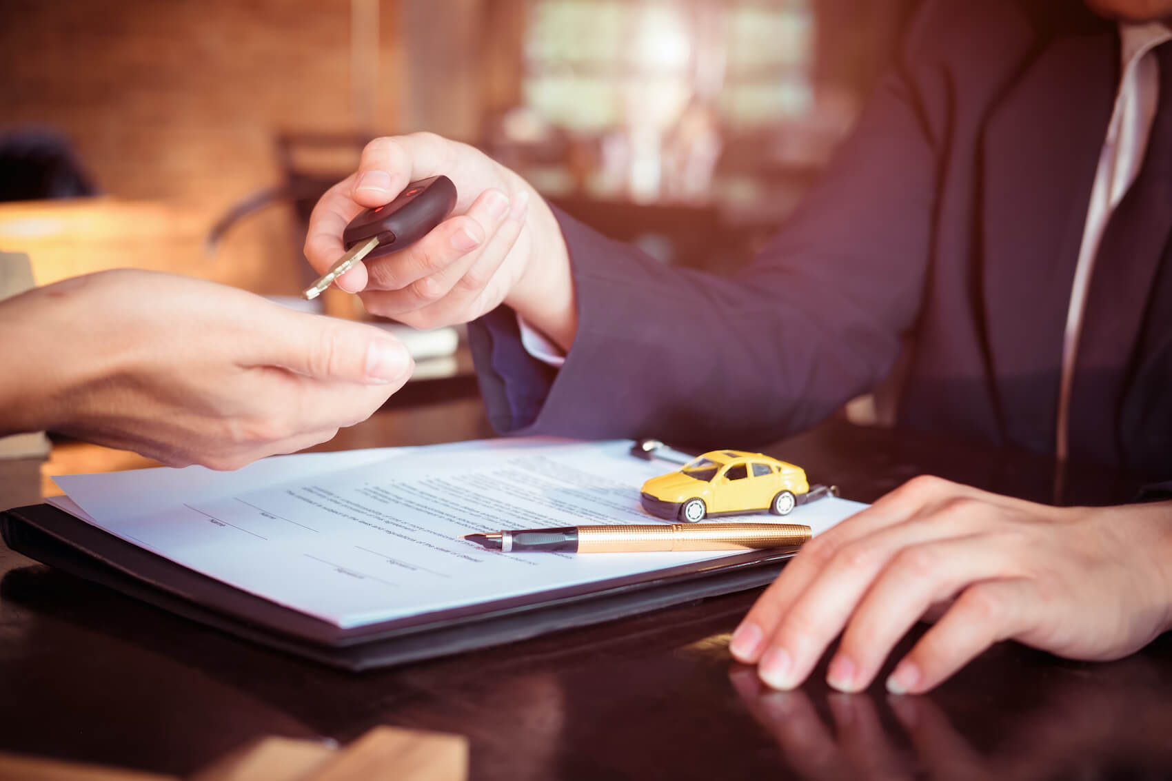 Sales man handing car keys to customer